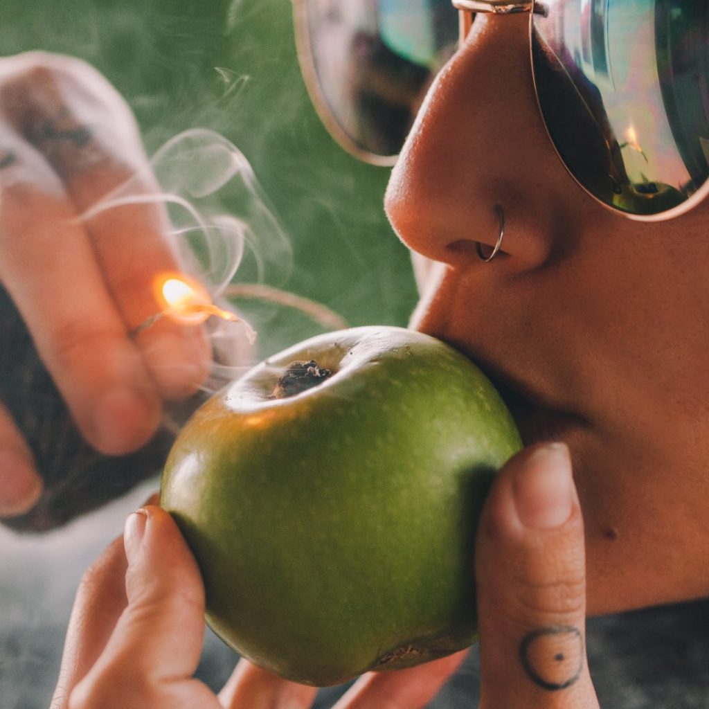 Smoking weed using a green apple.